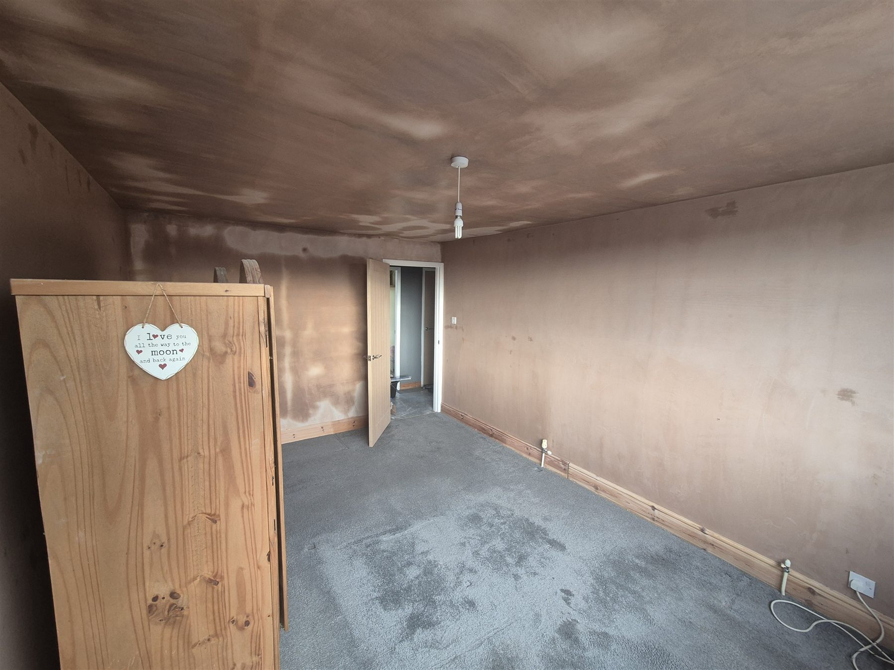 The same bedroom looking towards the door after wall and ceiling plastering