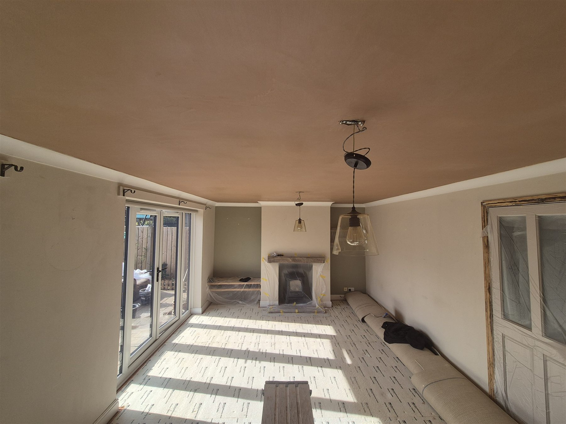 Smooth freshly plastered living room ceiling above pendant lights